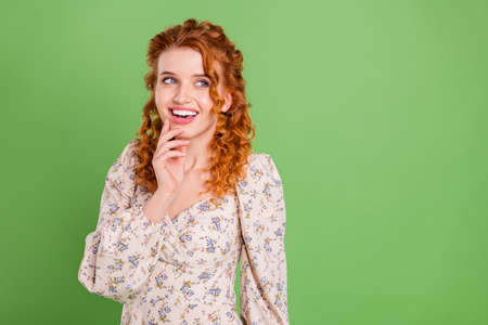 Photo of pretty happy ginger lady look empty space think minded smile isolated on green color...