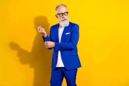 Photo of serious grey beard aged man pose wear spectacles blue jacket isolated on vivid yellow color...