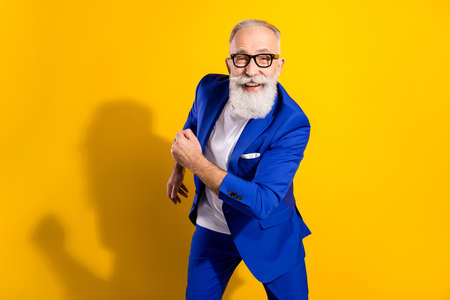 Portrait of attractive funky cheerful man dancing having fun isolated over bright yellow color...