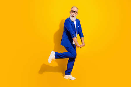 Full size profile side photo of amazed shy old funny man wear glasses shock isolated on yellow color backgroundの写真素材