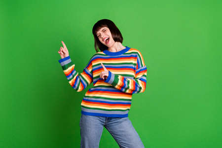 Photo of cheerful happy joyful young woman good mood dance sing point finger empty space isolated on...