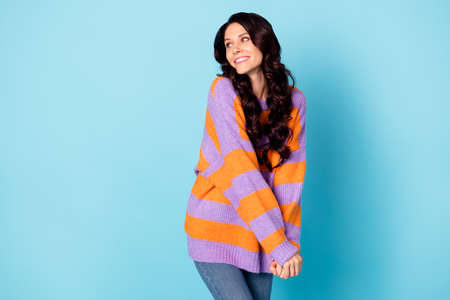 Portrait of attractive cheerful shy wavy-haired girl looking aside copy empty blank space isolated over bright blue color backgroundの写真素材