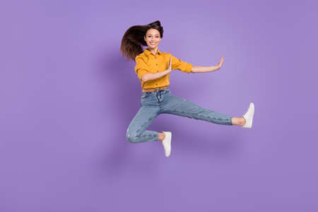 Full length body size side profile photo jumping girl practising martial arts isolated pastel purple...