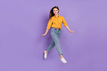 Full length body size photo jumping girl smile walking in casual outfit isolated violet color...