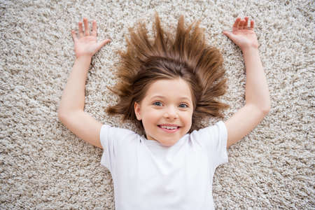 Top view little girl laying on floor smiling cheerful relaxing after school