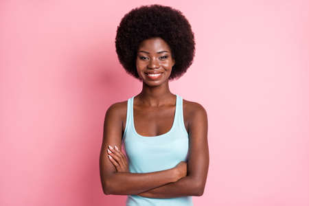 Portrait of optimistic brunette curly lady crossed arms wear blue top isolated on pink color backgroundの写真素材