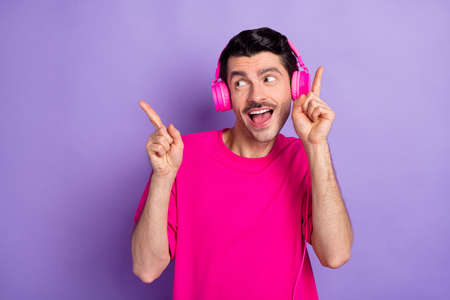 Photo of sweet funky young man wear pink t-shirt listening music headphonesの写真素材
