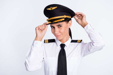 Photo of charming confident lady adjust headwear wear aviator uniform isolated white color backgroundの写真素材