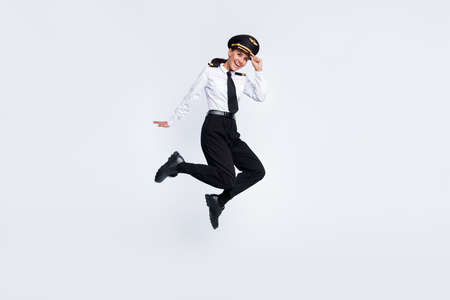 Full length body size view of pretty cheerful pilot girl jumping having fun business trip isolated over white color backgroundの写真素材