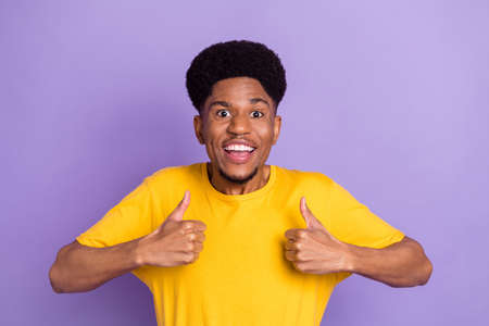 Photo of cheerful young dark skin happy man make thumbs up recommend isolated on violet color...