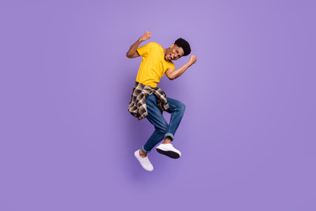 Full length body size view of attractive cheerful lucky guy jumping rejoicing isolated over violet...