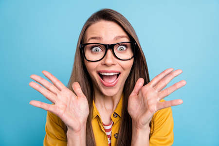 Photo of young woman happy positive smile amazed excited surprised news hands information isolated over blue color backgroundの写真素材