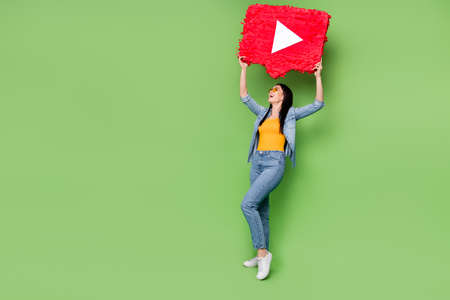 Full size photo of young happy excited crazy woman hold red ply button above head isolated on green color backgroundの写真素材