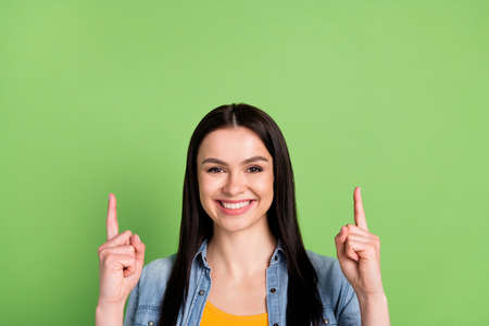 Photo of cheerful nice brown long hairdo lady point empty space wear jeans shirt isolated on pastel...