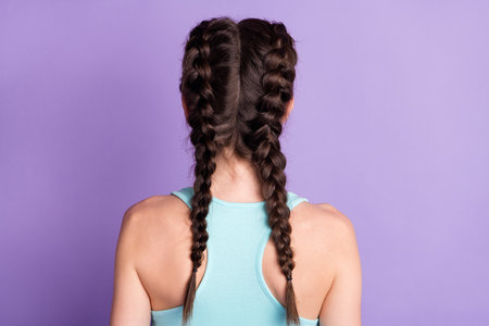 Back view photo of young woman wearing singlet braids isolated on pastel violet color backgroundの写真素材