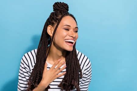 Photo portrait of girl with dreadlocks smiling laughing hand on chest isolated pastel blue color backgroundの写真素材