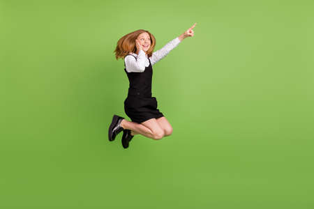 Full length body size view of attractive cheerful impressed girl jumping showing copy space isolated...