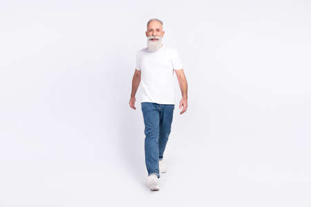 Full length body size view of attractive content cheerful man walking isolated over light grey color...
