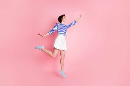 Full size profile side photo of young beautiful happy excited crazy girl jump look copyspace isolated on pink color backgroundの写真素材