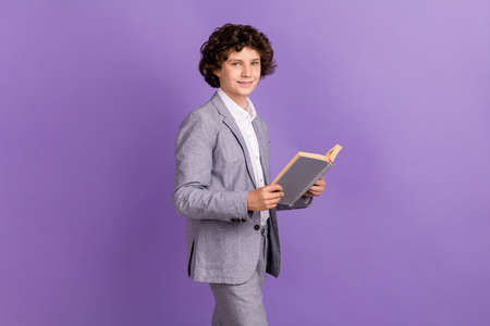 Photo of positive little guy sit walk hold textbook read wear grey suit isolated violet color...