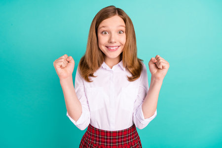 Portrait of attractive cheerful girl having fun goal achievement isolated over vibrant teal turquoise color backgroundの写真素材