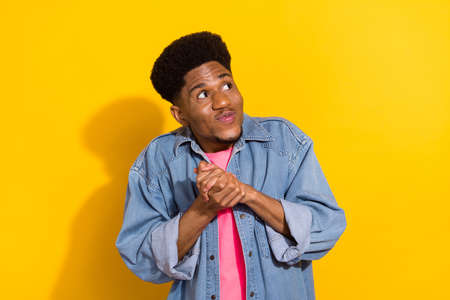 Photo of young funky afro american man look empty space plan think idea isolated on yellow color backgroundの写真素材