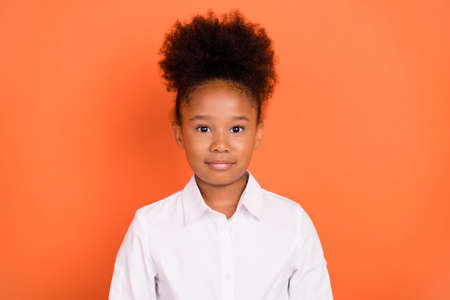 Photo of young attractive african girl happy positive smile confident wear shirt isolated over orange color backgroundの写真素材