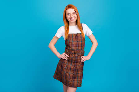 Photo of young attractive girl happy positive smile wear school uniform isolated over blue color backgroundの写真素材