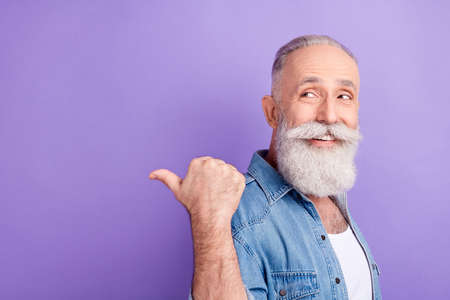 Photo of charming pretty mature man dressed denim outfit looking pointing back finger empty space...
