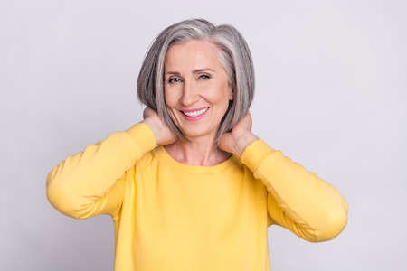 Portrait of happy cheerful good mood sweet beautiful woman with new pretty haircut isolated on grey color backgroundの写真素材