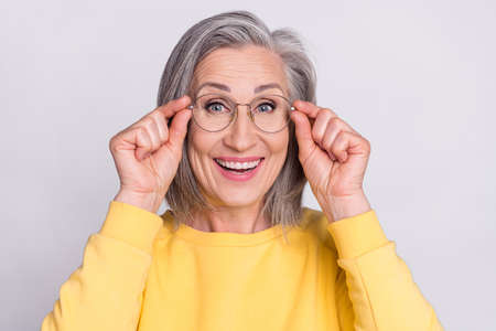 Portrait of mature good looking cheerful amazed woman in glasses see huge sale discount isolated on grey color backgroundの写真素材