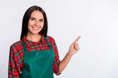 Photo of charming happy nice young woman point finger empty space seller isolated on grey color...