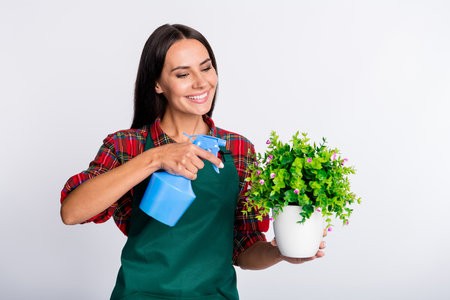 Photo of happy cheerful young woman look water plant occupation garden isolated on grey color...