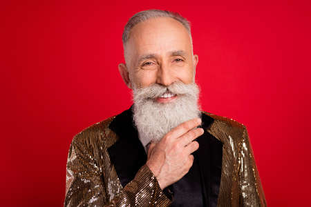 Photo of cheerful positive old man smile good mood wear costume presenter isolated on red color...