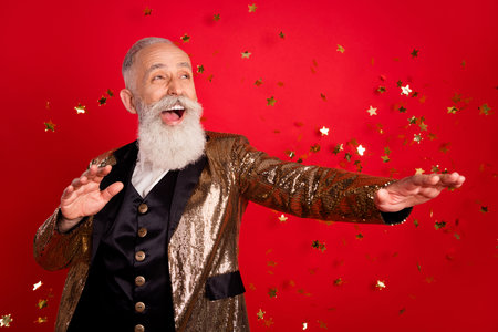 Photo of senior man happy positive smile excited fly air serpentine party isolated over red color...