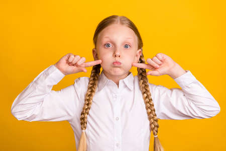Portrait of excited carefree person hold breath finger touch cheeks look camera isolated on yellow...