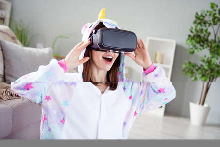 Photo of funny astonished dream cheerful lady enjoy realistic video game wear vr goggles kigurumi...