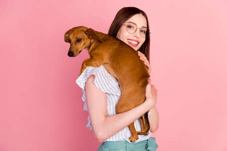 Photo of cute brunette millennial lady hold dog wear eyewear white blouse isolated on pink color backgroundの写真素材