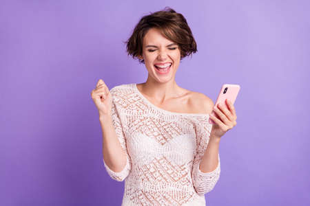 Photo of delighted ecstatic girl closed eyes fist up open mouth shout yes celebrate isolated on...
