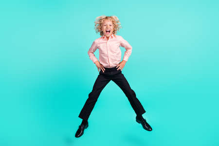 Full length body size view of nice ecstatic cheerful boy jumping having fun isolated over bright teal turquoise color backgroundの写真素材