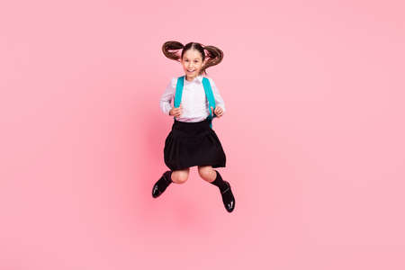 Full body photo of young happy positive cheerful girl jump up wear bag long socks smile isolated on pink color backgroundの写真素材