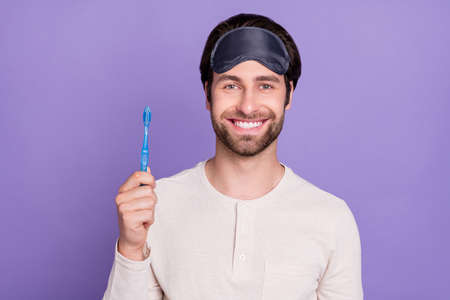 Portrait of cheerful person beaming smile hold toothbrush look camera isolated on violet color...