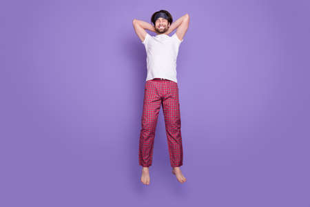 Full body portrait of peaceful cheerful person closed eyes arms behind head weekend isolated on violet color backgroundの写真素材