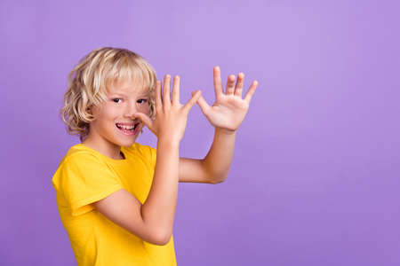Photo of cheerful young happy positive boy fooling hold fingers nose joke isolated on purple color...