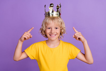 Photo of reliable promoter kid direct finger golden diadem wear yellow t-shirt isolated violet color...