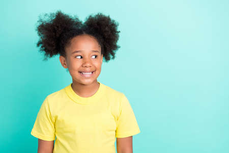 Photo of pretty brunet small girl wear yellow t-shirt isolated on teal color backgroundの写真素材