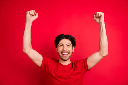 Photo of young man happy positive smile rejoice win victory lucky success goal fan isolated over red...