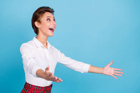 Profile photo of astonished blond young lady hold hands wear shirt isolated on blue color backgroundの写真素材
