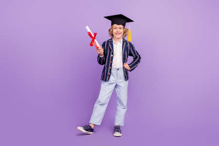 Full length body size view of nice smart clever cheerful schoolboy holding letter isolated over purple violet color backgroundの写真素材