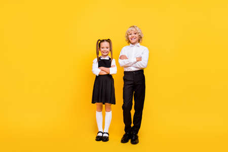 Full size portrait of two satisfied school persons folded hands look camera isolated on yellow color...